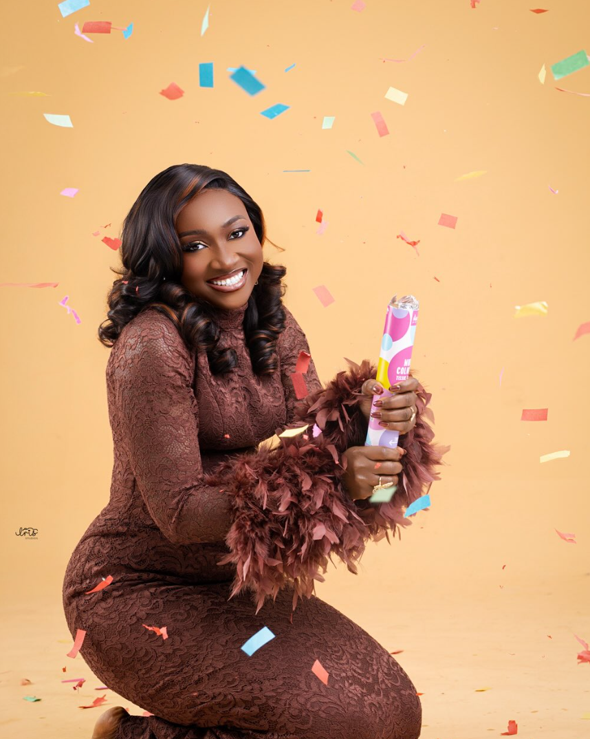 Celebration portrait with confetti against a warm mustard backdrop